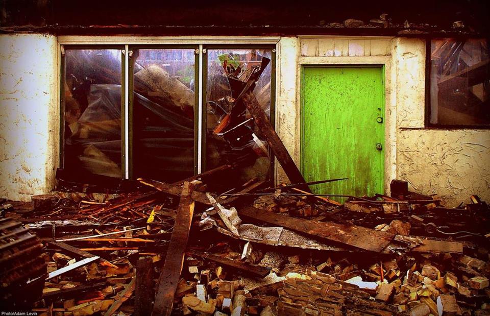 Near a bright green door wood, nails, rubble and broken glass litter the inside and outside of Sydney Hih as it was dismantled.
